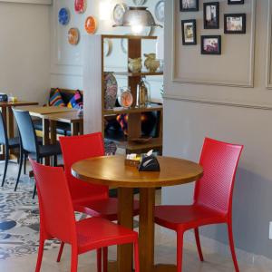 stół i czerwone krzesła w restauracji w obiekcie Hotel Maraja w mieście Uberlândia