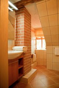 La salle de bains est pourvue d'un lavabo et d'un mur en briques. dans l'établissement Logierhaus Lehde, à Kaupen