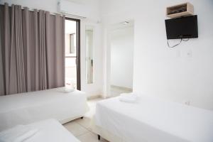 2 camas en una habitación con TV en la pared en Plaza Inn Trevo Sorocaba, en Sorocaba