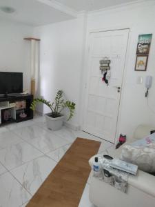 a white living room with a door and a couch at Apto na Praia in Guarapari