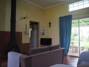 a living room with a couch and a fireplace at Riverview Country Inn in Van Reenen