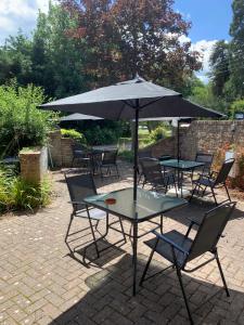 una mesa y sillas con una sombrilla en el patio en Playden Oasts Hotel en Rye