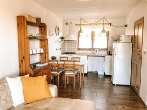 a kitchen and dining room with a table and a refrigerator at Fajne Domki in Władysławowo-Chłapowo