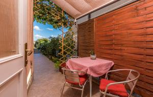 a table and chairs on a patio with a fence at Apartments Stanisic in Fažana