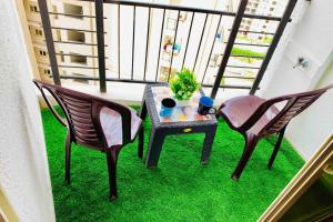 a balcony with two chairs and a table on the grass at The Friend’s Square near IndiaExpo Mart in Noida