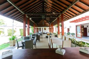 ein Restaurant mit Tischen und Stühlen und einem Dach in der Unterkunft Swanee Grand in Negombo