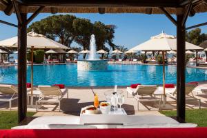 einen Pool mit einem Tisch, Stühlen und einem Brunnen in der Unterkunft Hotel Don Pepe Gran Meliá in Marbella