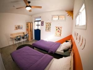 two beds in a room with purple sheets at Odem Guest House in Odem
