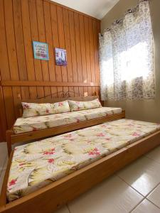 um quarto com 2 camas e uma janela em Recanto Marina em Guarda do Embaú