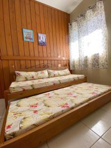 a bedroom with two beds and a window at Recanto Marina in Guarda do Embaú