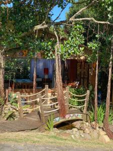 a wooden deck with a swing in front of a house at Recanto Marina in Guarda do Embaú