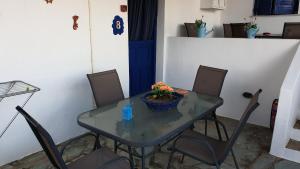 a table with chairs and a bowl of flowers on it at Galazio Kyma in Agios Ioannis