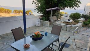 a table and chairs with a bowl of flowers on it at Galazio Kyma in Agios Ioannis