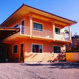 Casa de color naranja con balcón y entrada en Amplo Apartamento na Pinheira en Palhoça
