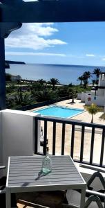 a glass bottle sitting on a table on a balcony at Casa Mykonos 1° linea de mar en Playa Blanca in Playa Blanca
