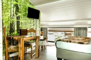 a bedroom with a table and a bed and a tv at Hoeve Chartreuse in Bruges