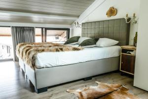 een slaapkamer met een groot bed en een faux pelsdeken bij Hoeve Chartreuse in Brugge
