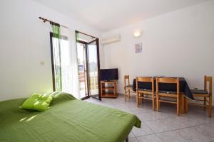 1 dormitorio con cama verde, mesa y sillas en Apartments Marko 527, en Drage