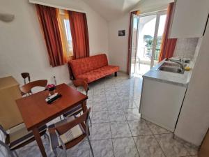 a living room with a table and a kitchen at Apartmani Šaldi in Pakoštane