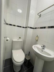 uma casa de banho branca com um WC e um lavatório em Modern Studio in King's Cross and St Pancras em Londres