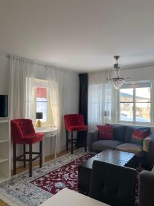 a living room with a couch and red chairs at Varijlyan höger in Sälen