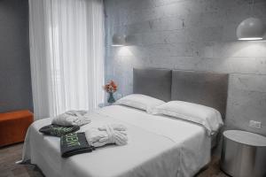 a bedroom with a white bed with towels on it at AmbientHotels Panoramic in Rimini