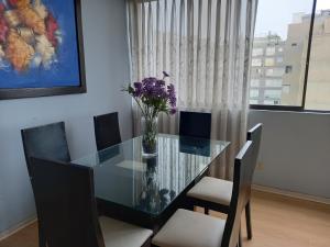 a dining room table with a vase of flowers on it at apartamento CAA pardo in Lima
