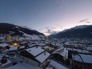 una città ricoperta di neve con montagne sullo sfondo di Appartamento Centro Storico a Bormio