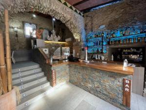 a bar in a restaurant with a counter and stairs at Hotel Mas Palou in Roses
