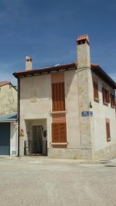 un edificio blanco con puertas marrones en una calle en Casa Rural el Herrero de Pollos, en Pollos