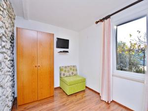 a room with a green chair and a window at Apartments Adriana in Rabac