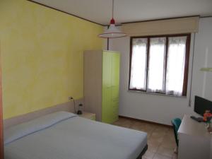 una camera con letto e armadietto verde di Albergo Ristorante Gori ad Ameglia