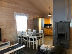 uma cozinha e sala de jantar com mesa e cadeiras em Luppocee em Ylläsjärvi