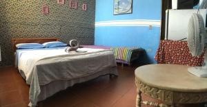 a bedroom with two beds and a table and a chair at Pousada Paraíso in São Thomé das Letras