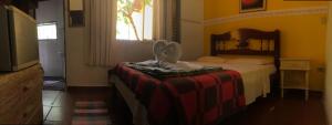 a bedroom with a bed with aulture sitting on a blanket at Pousada Paraíso in São Thomé das Letras