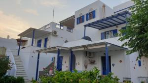 a white building with blue doors and windows at Galazio Kyma in Agios Ioannis
