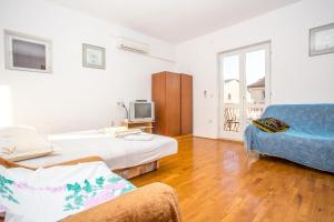 a room with two beds and a couch and a tv at Apartments Nuic in Makarska