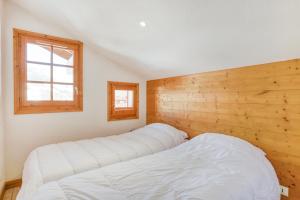 a bedroom with a bed and a window at Schuss 2 - Appartement 2 chambres - Val d'Arly in Flumet