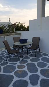 a patio with a table and chairs on a rug at Galazio Kyma in Agios Ioannis