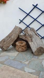 a pair of logs sitting next to a wall at Galazio Kyma in Agios Ioannis