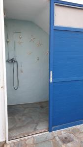 a blue door in a room with a shower at Galazio Kyma in Agios Ioannis