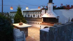 a backyard with a fireplace and a table and chairs at Galazio Kyma in Agios Ioannis