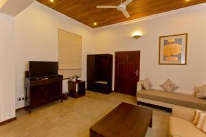 a living room with a couch and a tv at Swanee Grand in Negombo