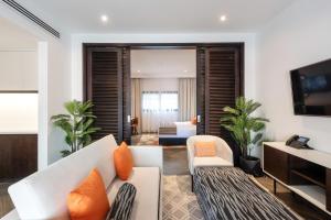 منتجع الامارات بارك في أبوظبي: غرفة معيشة مع أريكة بيضاء ووسائد برتقالية