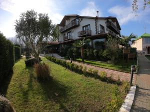 Una casa grande con un jardín enfrente. en Cevizdibi Hotel, en Masukiye