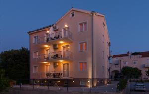 a large white building with balconies on the side of it at Apartments Island Beat in Supetar