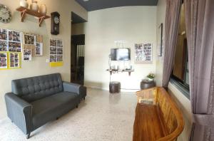 a living room with a couch and a tv at Austin Homestay in Ipoh