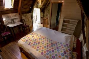 a bedroom with a bed with polka dot sheets at Gite A'mour Charlannes in Hautefage