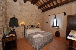 a bedroom with a bed and a stone wall at Agriturismo Borgo San Martino in Abbateggio