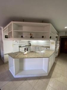 a kitchen with white cabinets and a counter top at RondPoint Pilar in Pilar